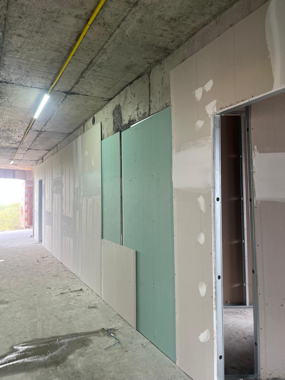 Acabamento fino em drywall com massa de acabamento no empreendimento Torre Evoke, demonstrando precisão técnica RIT